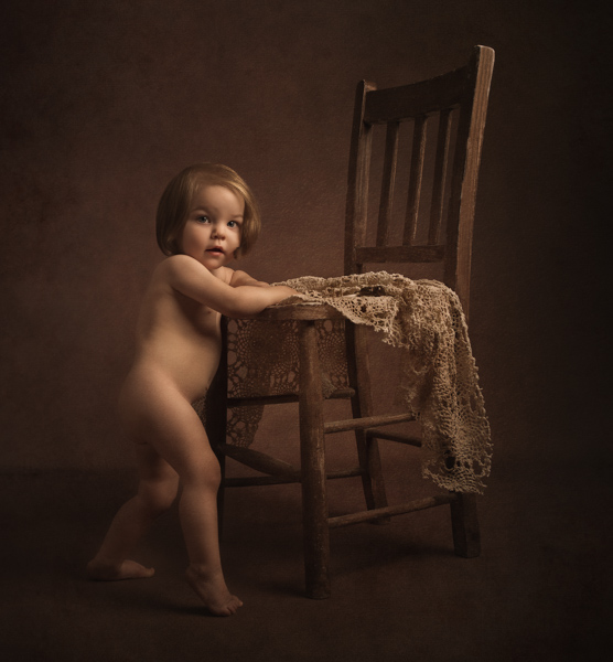 baby girl standing by chair