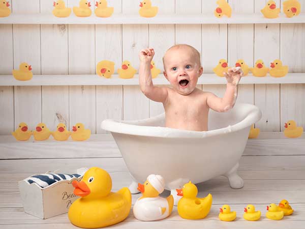 Gorgeous baby birthday photoshoot with ducks in a tub
