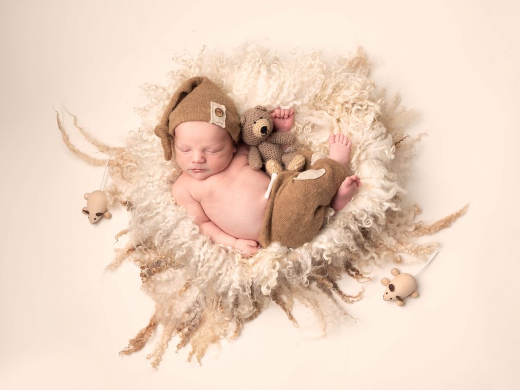newborn baby with bear and toys