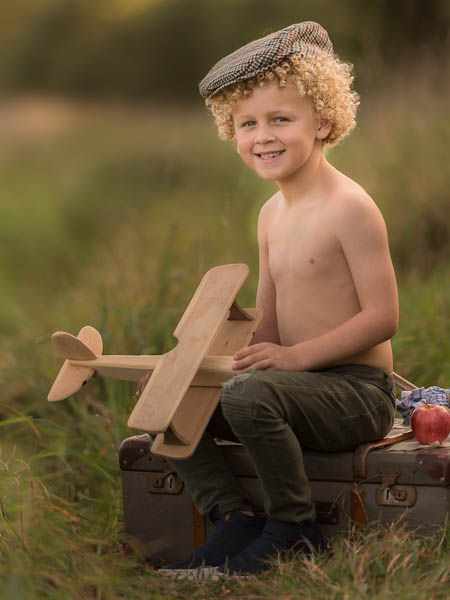 outdoor location photoshoot with young boy in autumn with plane