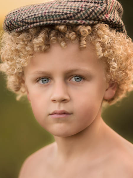 outdoor location photoshoot with young boy in autumn close up with flat cap