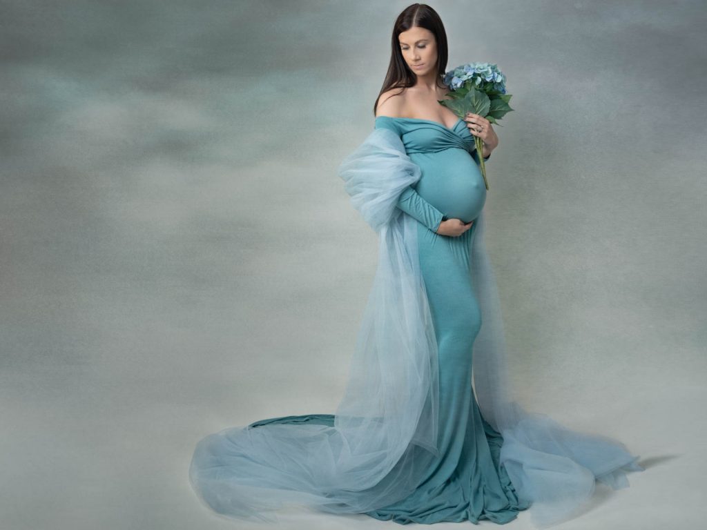 mother holding her pregnant tummy maternity photoshoot