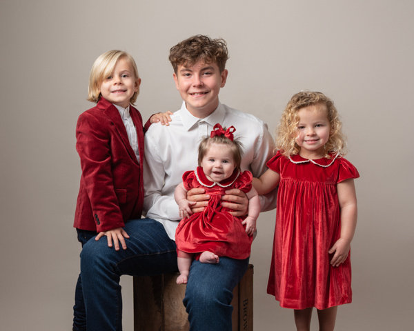 red themed family photoshoot with beautiful baby girl in the center