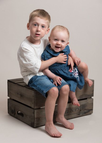 two little children sitting on a crate