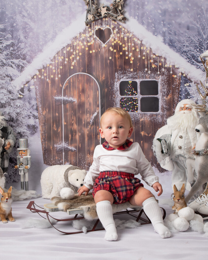 Cute baby on sledge with polar bear and Santa