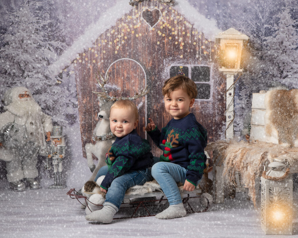 Two brothers in Christmas jumpers on ledge photo shoot