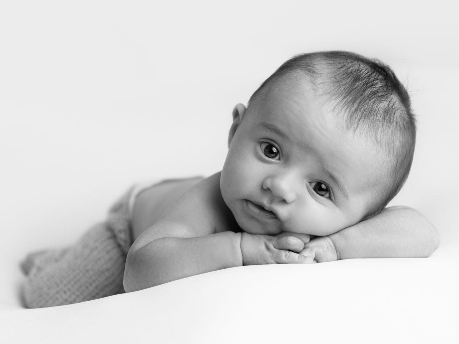 newborn baby awake lying casually in black and white photo